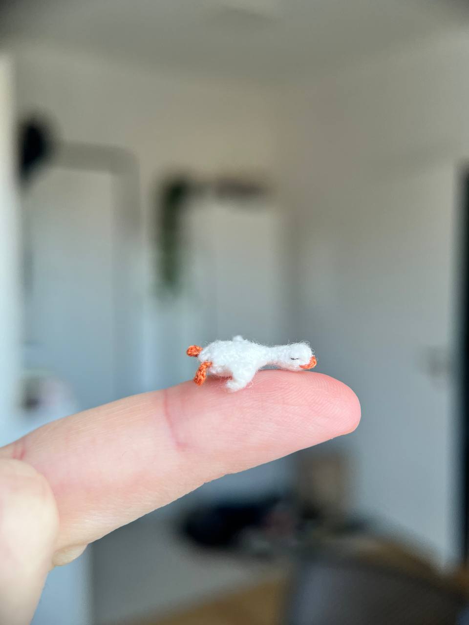 Super tiny crochet frog with a plush goose