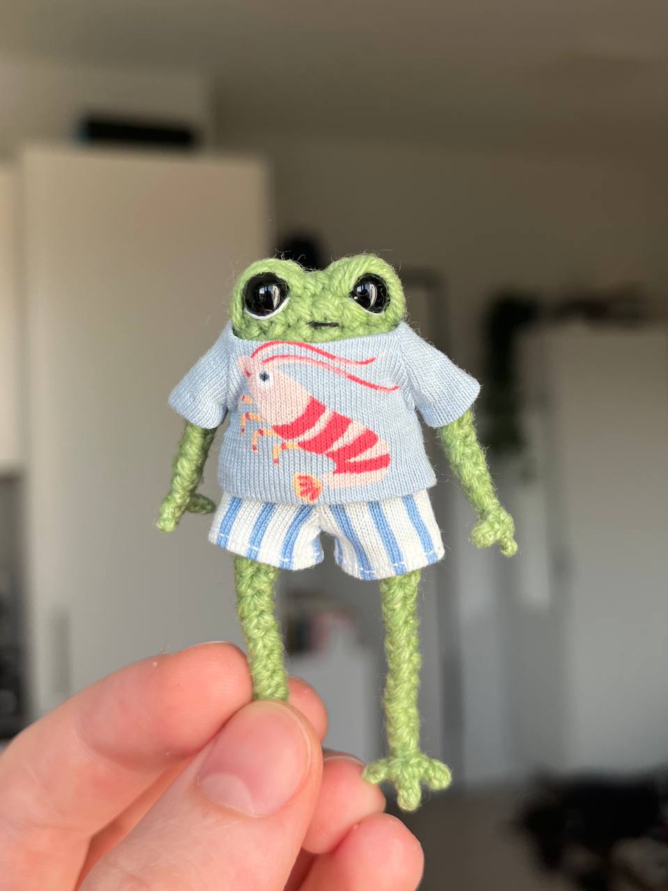 Small crochet frog in a shrimp outfit